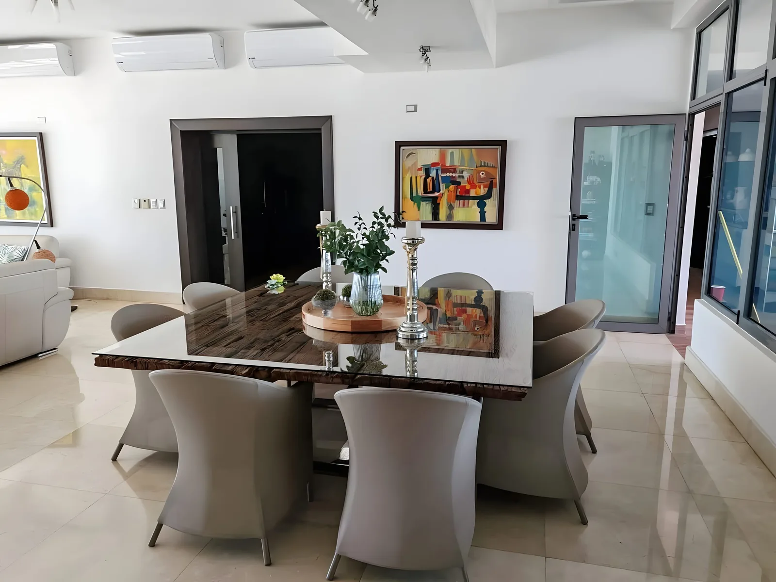 Dining room with a stone-top table for eight and paintings on the walls