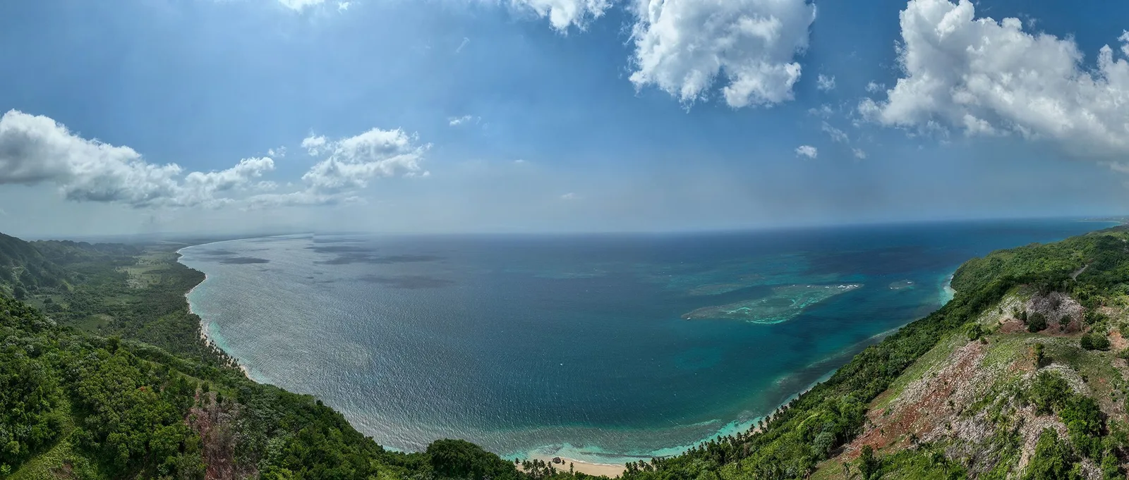 Amplia panorámica desde las lomas sobre la bahía, el arrecife y la costa