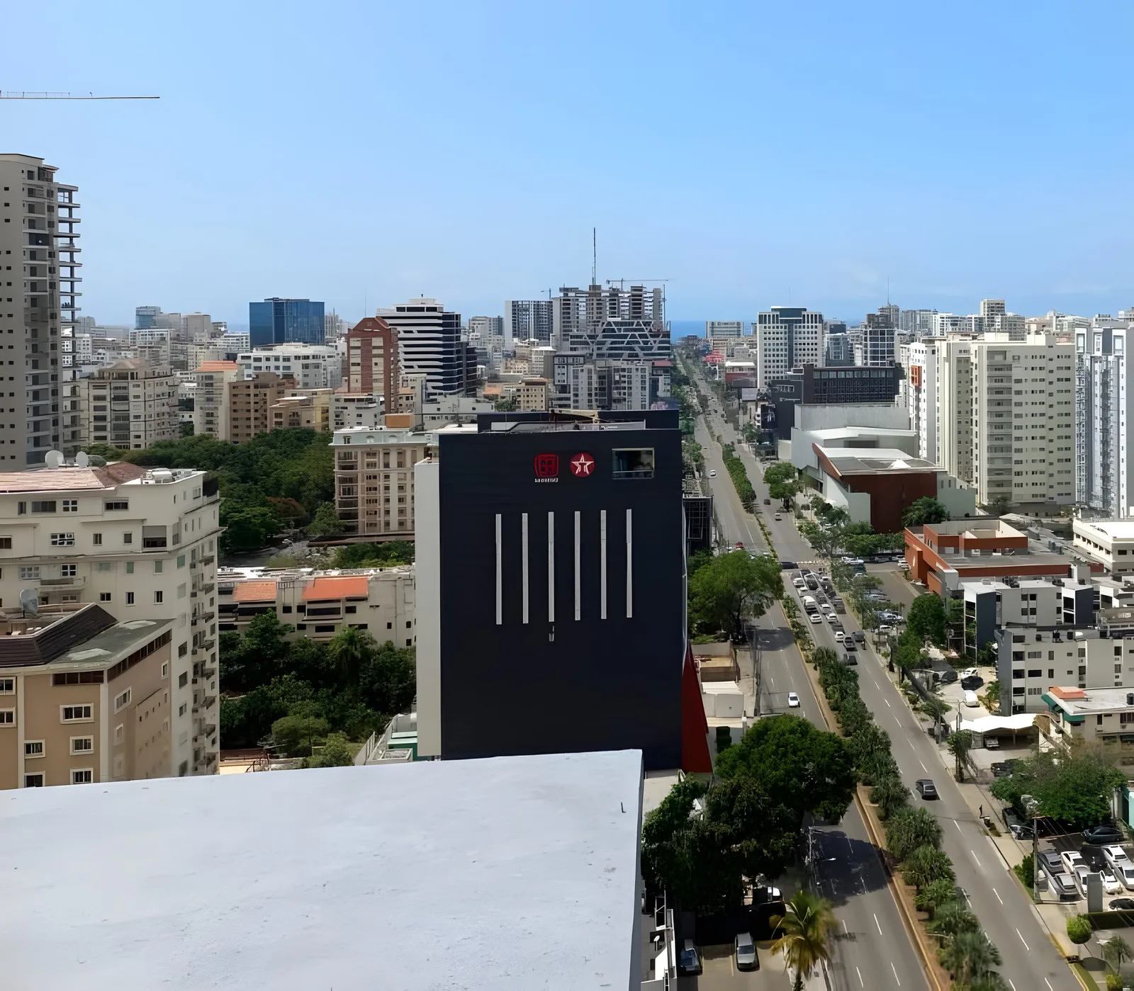 View down a long avenue lined with towers, the sea on the horizon